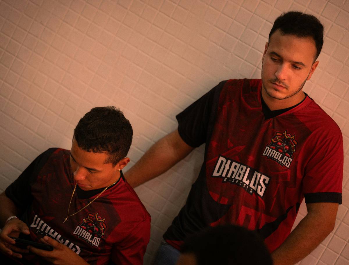 Competitive multiplayer mobile esports players focused on smartphones during an intense match
